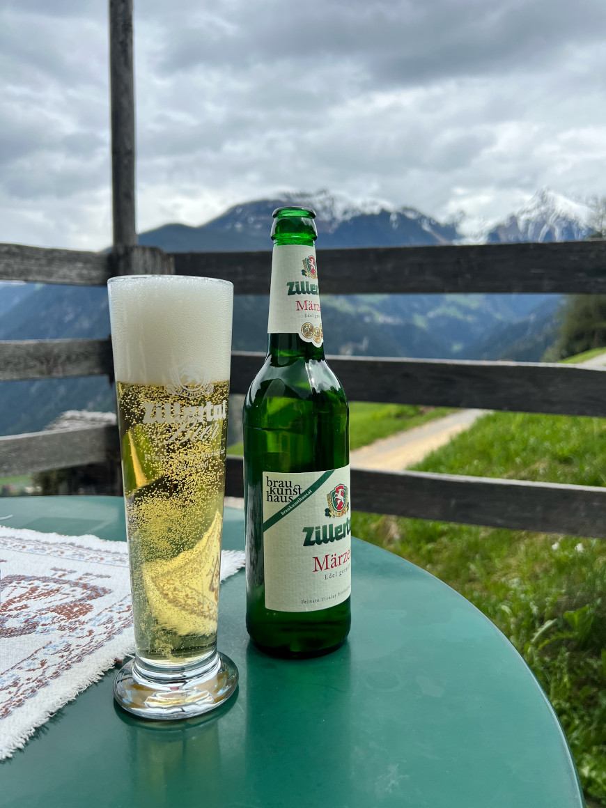 Bier auf dem Tisch des Wiesenhof-Gastgartens in Mayrhofen, im Hintergrund der Brandberger Kolm 