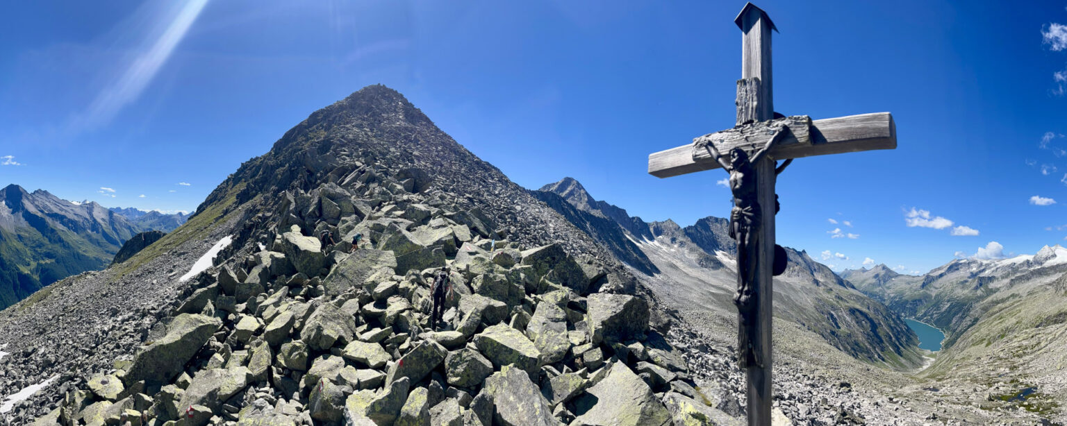 Gipfelkreuz des Heilig-Geist-Jöchl im Zillergrund mit dem Speicher Zillergrund im HIntergrund