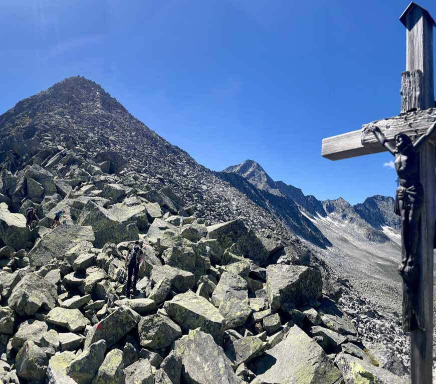 Gipfelkreuz des Heilig-Geist-Jöchl im Zillergrund mit dem Speicher Zillergrund im HIntergrund