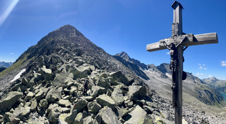 Gipfelkreuz des Heilig-Geist-Jöchl im Zillergrund mit dem Speicher Zillergrund im HIntergrund