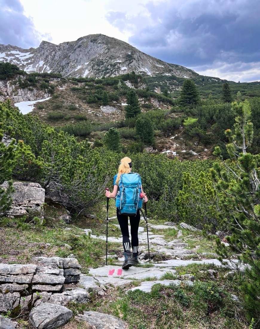 Frau auf einem breiten Wanderweg mit vielen Steinen, der von der Gerlossteinwand im Zillertal Richtung Kotahornalm führt
